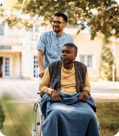 Resident in a wheelchair being assisted outdoors