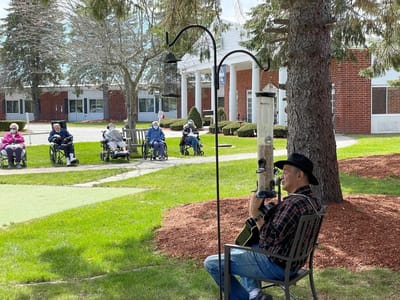 Residents enjoying a musical performance in the garden