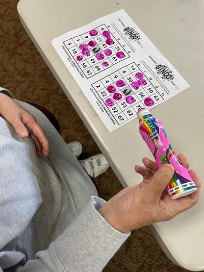 A resident playing bingo with colorful markers