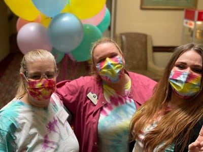 Staff members celebrating with balloons in a common area