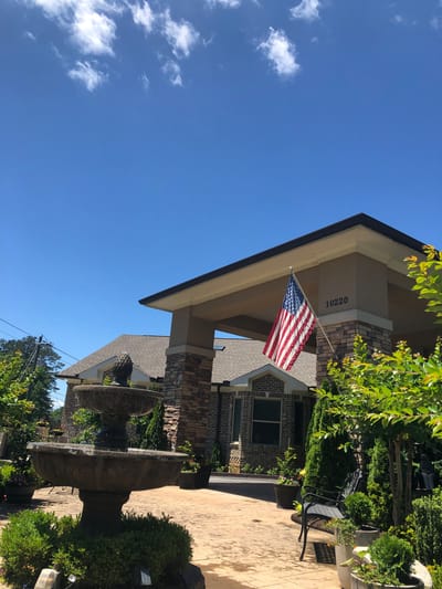 Exterior view of a senior living facility with an American flag