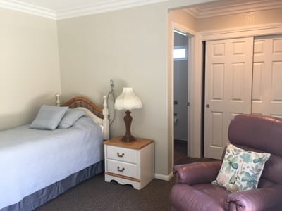 Cozy interior of a private resident room with a bed and chair
