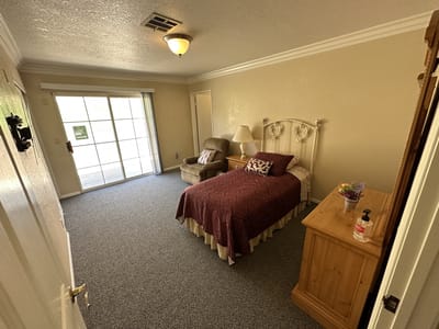 A cozy resident room with a bed and seating area