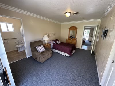 Bright, spacious resident room with a bed and chair