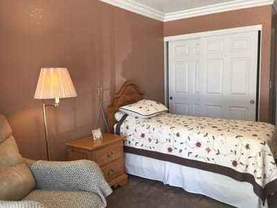 Cozy bedroom with a floral quilt and lamp