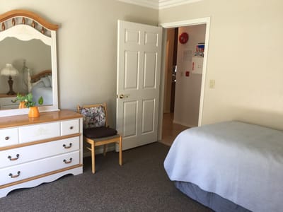 Cozy private resident room with a dresser and bed