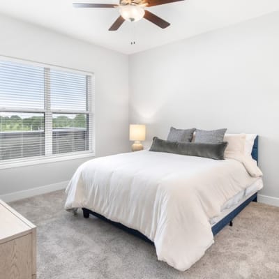 Cozy bedroom with a bed, lamp, and window