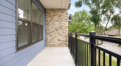 Outdoor balcony with stone accents and greenery