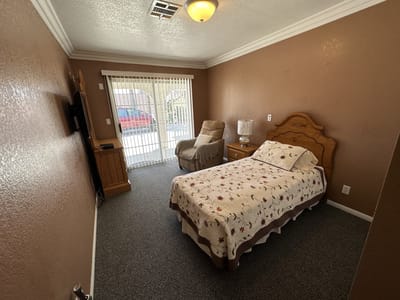 Cozy resident room with a queen bed and chair