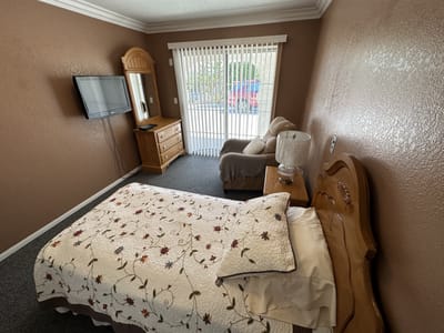 A cozy private room with a bed and chair