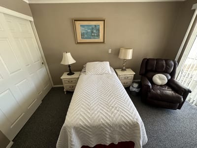 Cozy private resident room with a bed and armchair