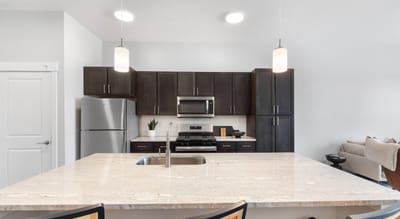 Modern kitchen area with granite countertops and appliances
