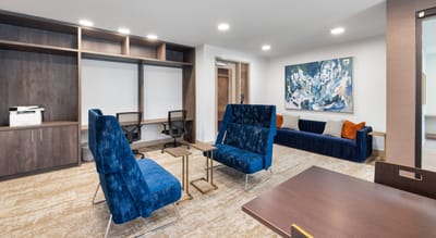 Interior lounge area with blue chairs and artwork