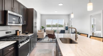 Modern kitchen area with living space in the background