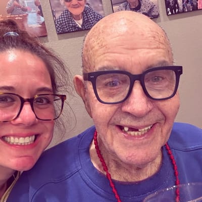 Resident and staff member smiling together in a common area