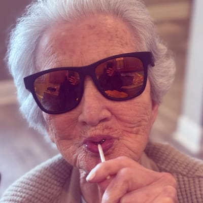 Elderly resident enjoying a lollipop with stylish sunglasses