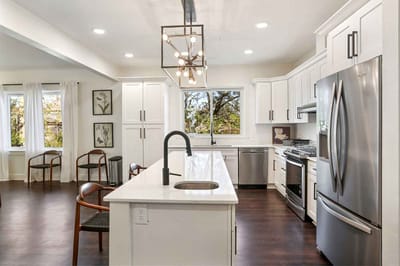 Modern kitchen area with white cabinets and seating