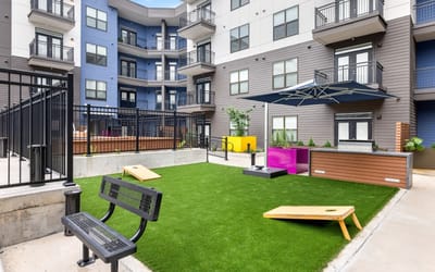 Well-maintained outdoor lounge area with green turf and seating
