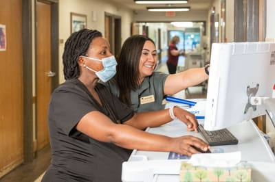 Staff members working together at a computer station