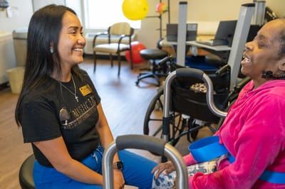 Staff member engaging with a resident in an activity room