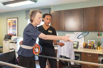 A staff member assisting a resident with therapy activities