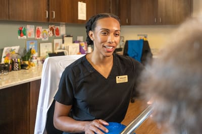 Staff member assisting a resident in an activity room