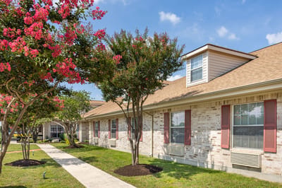 Exterior view of a nursing facility with landscaped pathways
