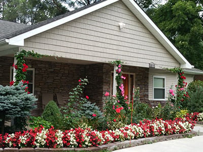 Exterior view of Orchard Manor Senior Care Home with flowers