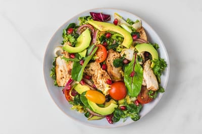 A vibrant salad with chicken and avocado.