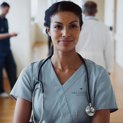 Nurse smiling in a healthcare facility hallway