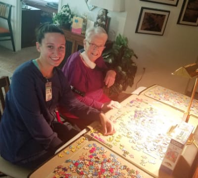 Resident and staff member enjoying puzzle activity