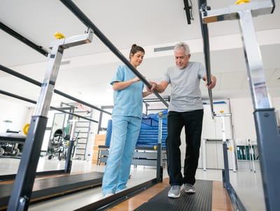 A staff member assisting a resident in rehabilitation
