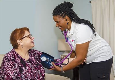 Nurse taking a resident's blood pressure in a home setting