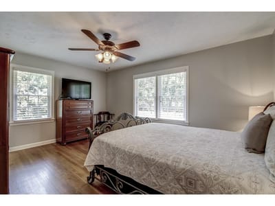 A well-furnished private room with a bed and TV
