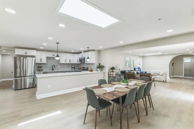 Bright, spacious common area with dining table and seating