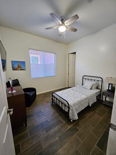 A well-furnished private resident room with a bed and chair