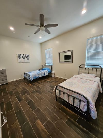 A shared resident room with two beds and a fan