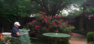 Resident sitting at a table in a lush garden