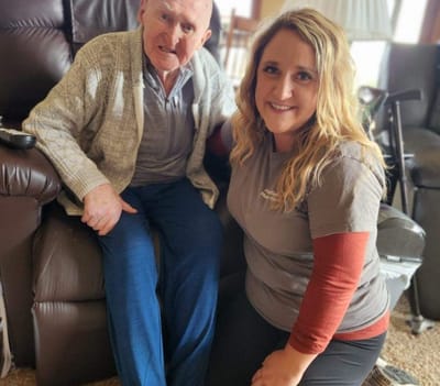 Resident and staff member smiling together