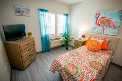 Brightly decorated private resident room with colorful bedding