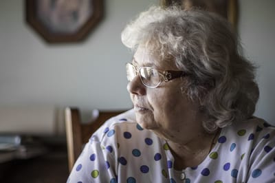 Senior woman with glasses sitting at a table