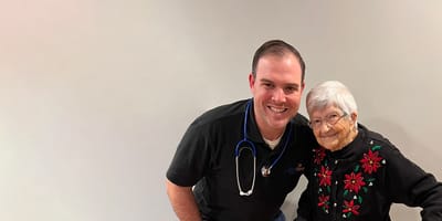 A staff member smiling with a resident in an indoor setting