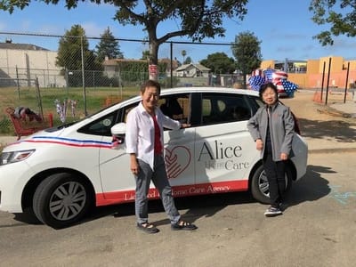 Two staff members beside an Alice Home Care agency vehicle