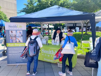 People interacting at a community event booth