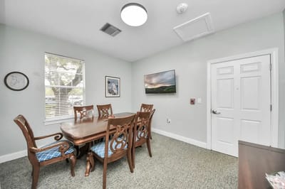 Bright common area with dining table and TV