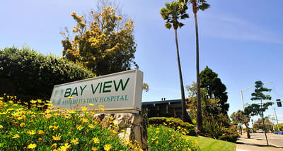 Signage for Bay View Rehabilitation Hospital surrounded by flowers