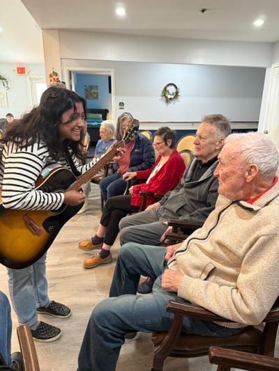 Resident enjoying music therapy session with a staff member