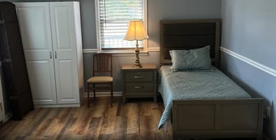 Cozy private room featuring a bed and lamp