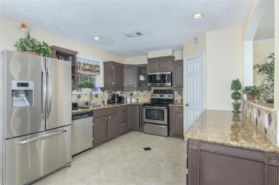 Bright kitchen with appliances and granite countertops