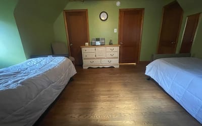 A private resident room with two beds and a dresser